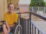 Disabled Person Dressed In Yellow In A Wheelchair
