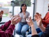 Men And Women Sitting In Circle During Group Therapy